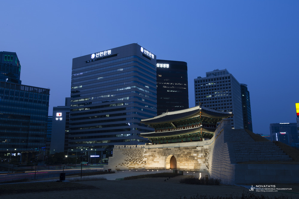 환한 조명이 비친 숭례문과 배경 고층 빌딩