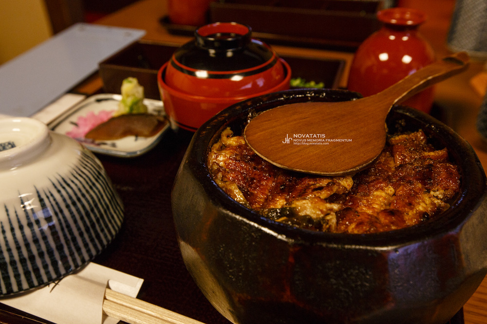 주걱 얹힌 돌솥 장어덮밥과 밑반찬