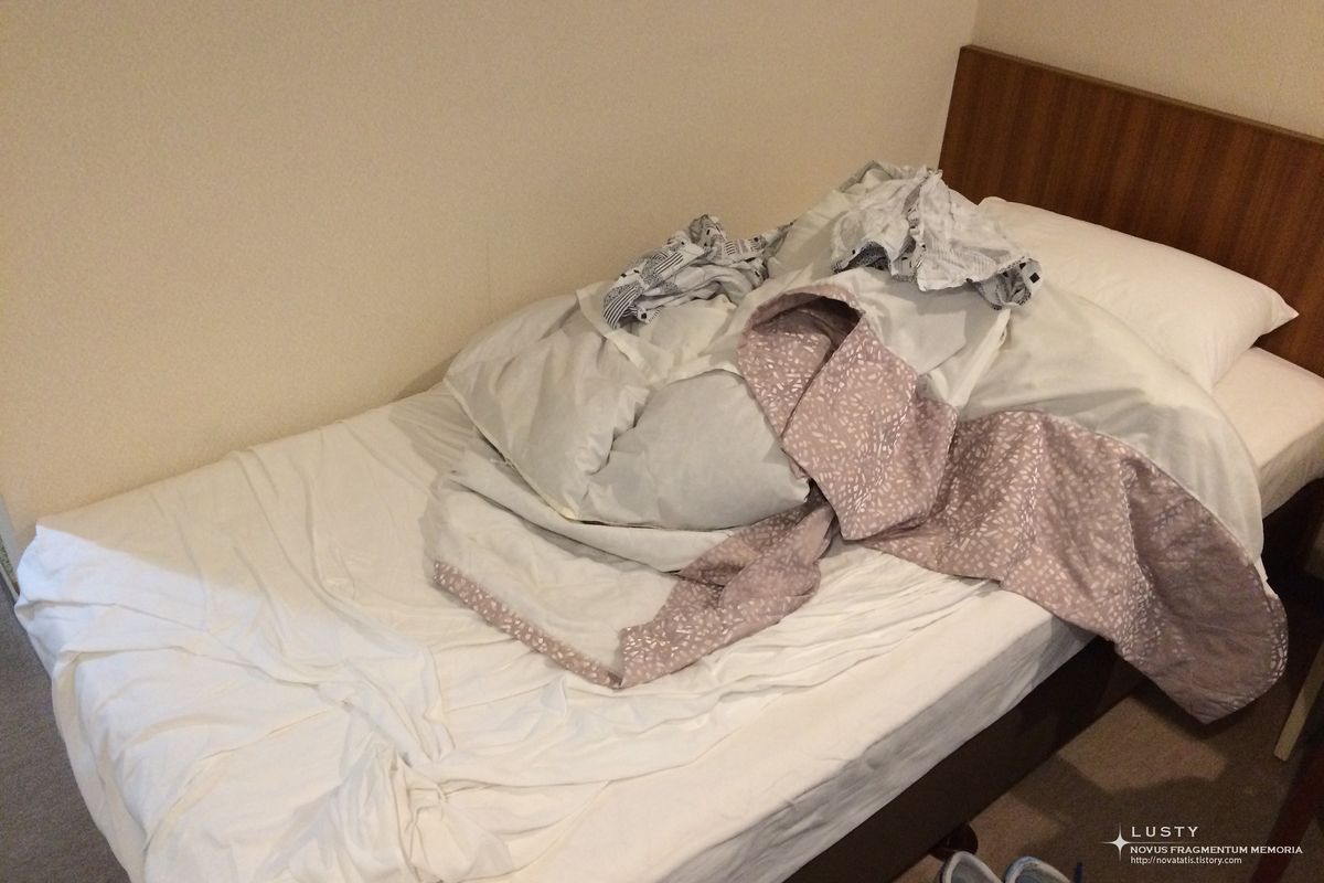 호텔 작은 침대 위 헝클어진 이불