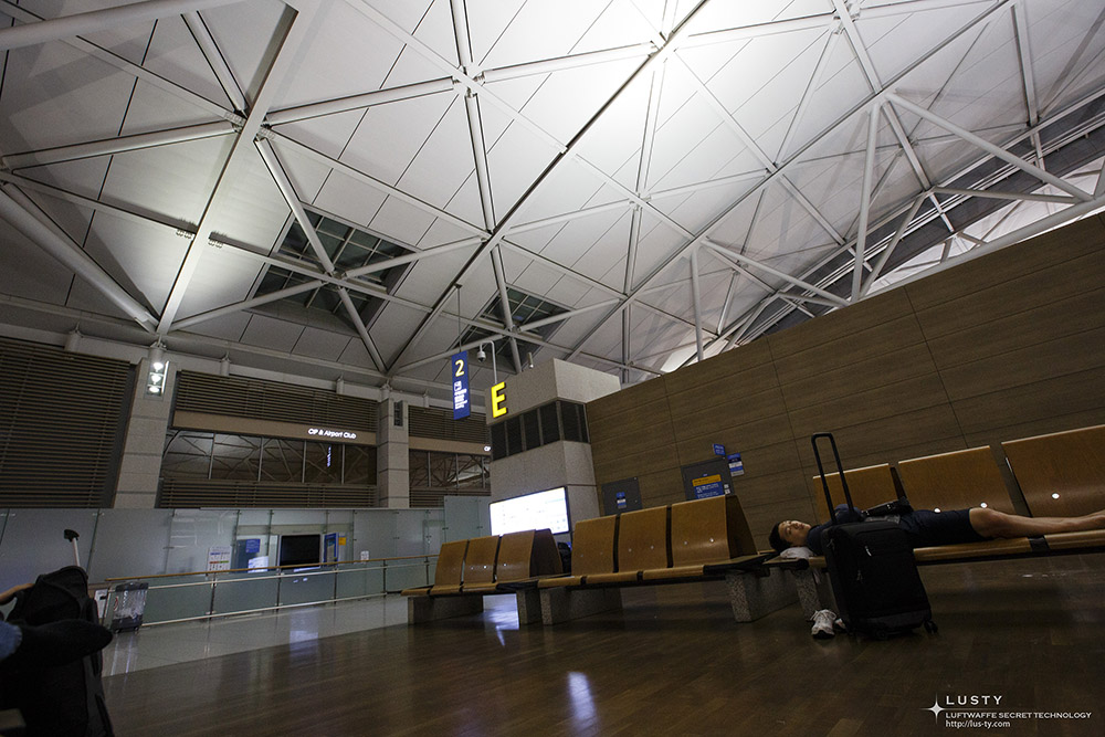 Gate E 대기 의자와 짐 있는 승객