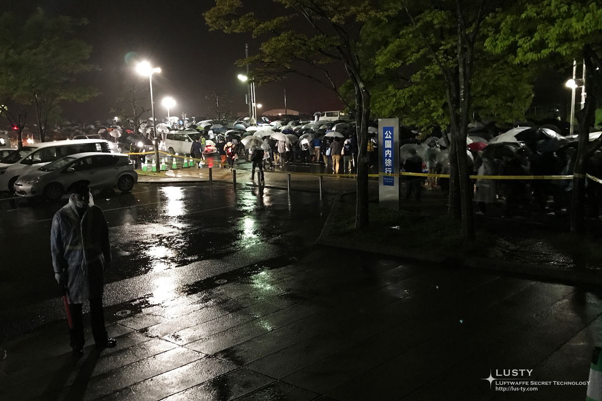 빗속 정문 주변 우산 든 관객들과 차량