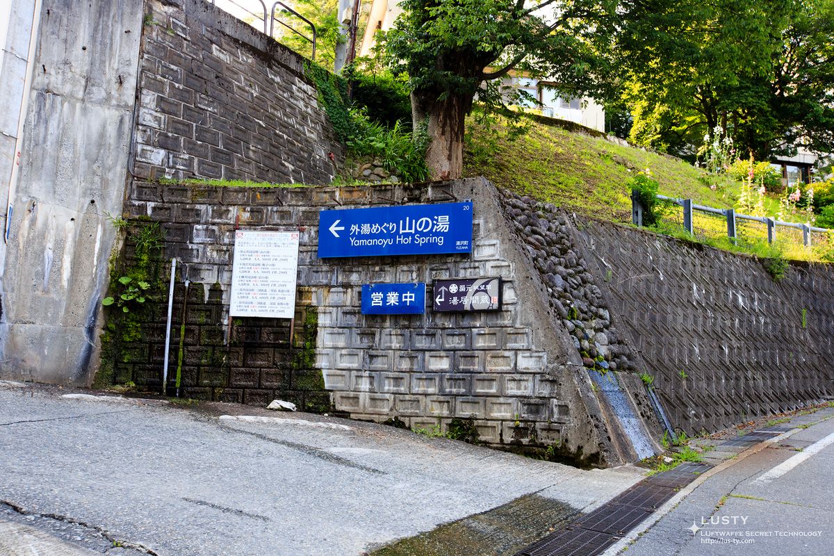 산장 온천 방향 파란 안내판과 돌담
