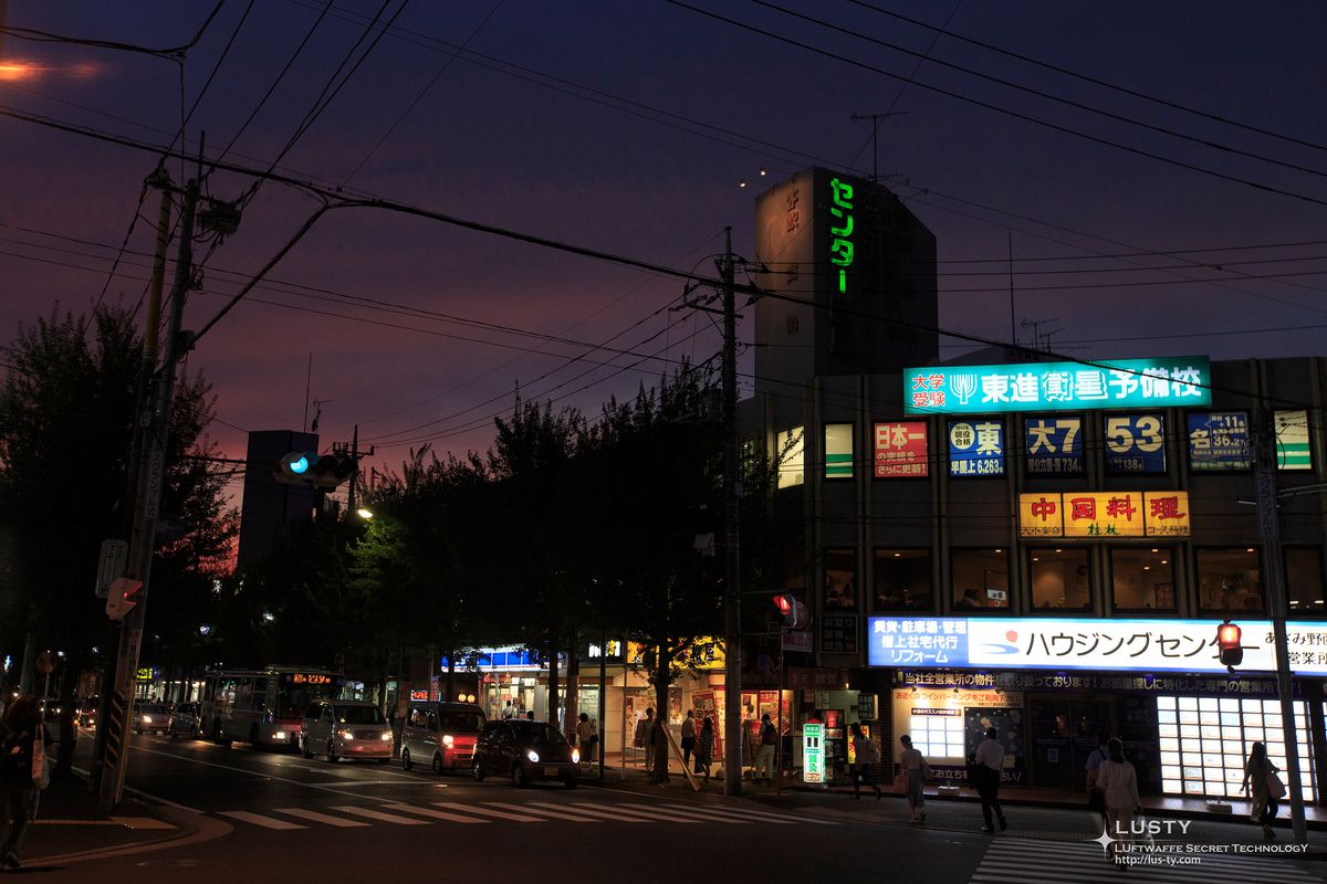 교차로의 가게 간판들과 지나가는 차량