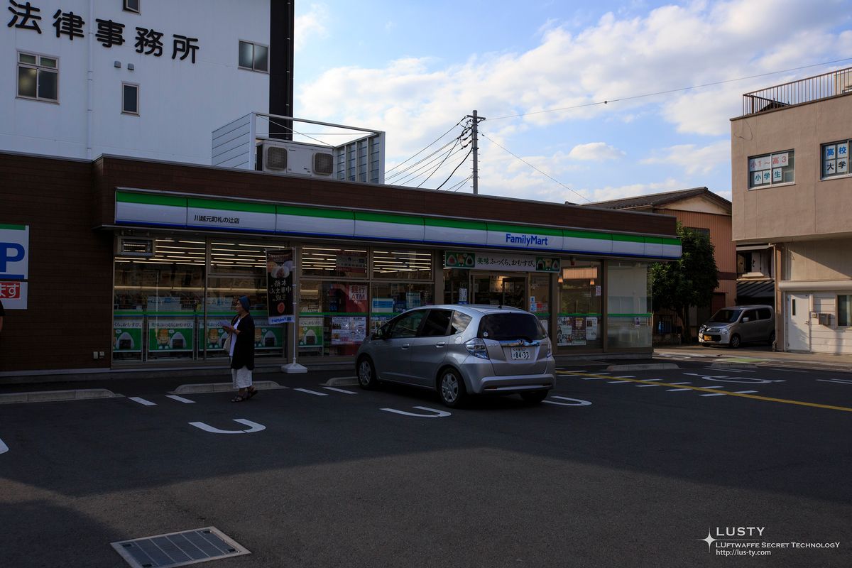 차와 하얀 건물 앞 FamilyMart 편의점