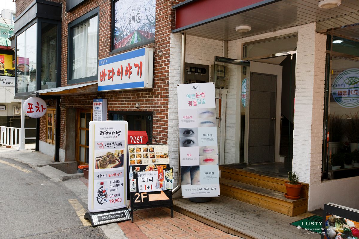 벽돌 건물과 식당 간판이 있는 골목 입구