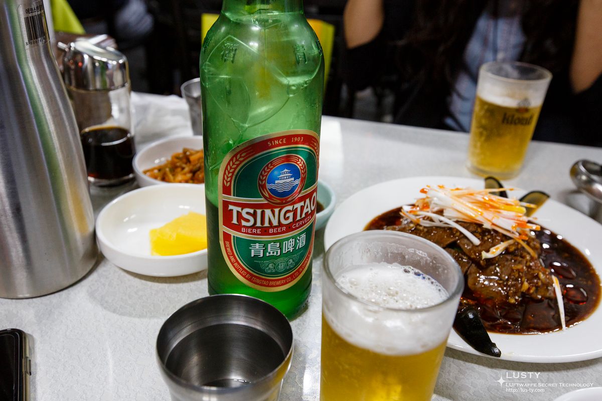 테이블 위 칭따오 병과 맥주잔