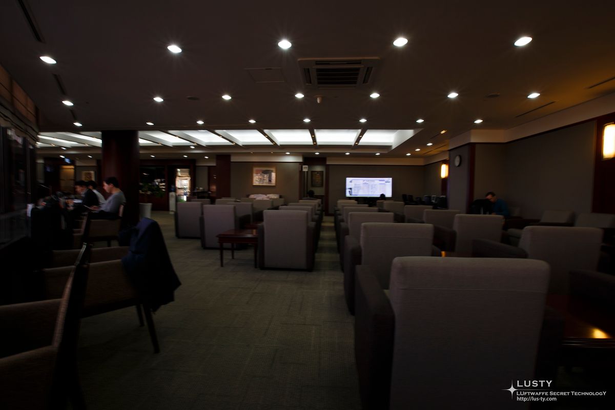 라운지 내부 소파 좌석과 중앙 전광판