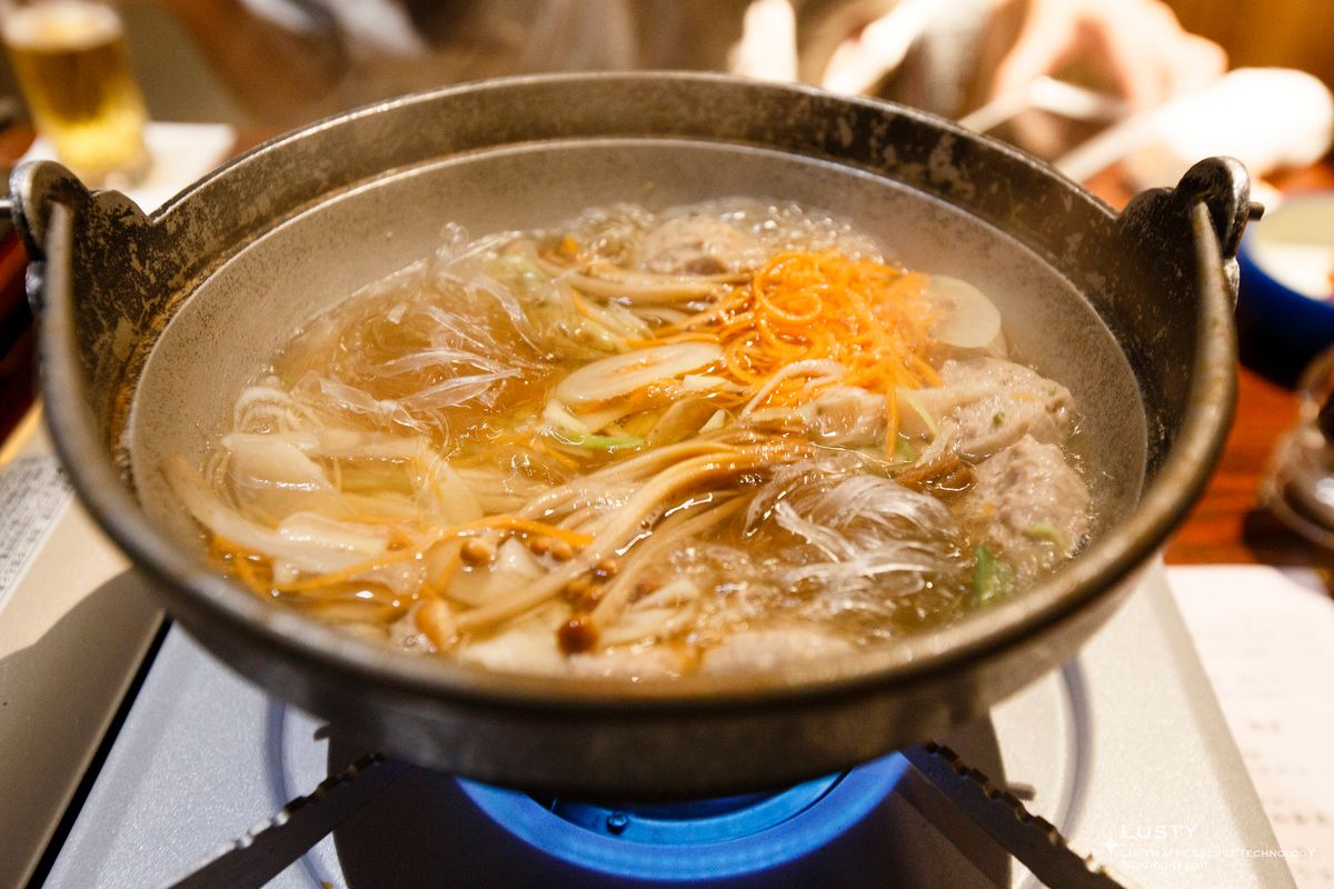 냄비에 육수와 당면, 버섯, 채소가 끓음