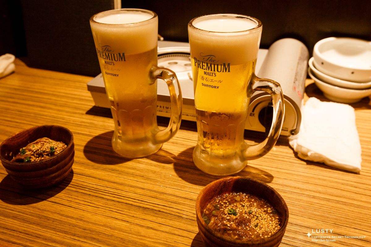 서로 나란히 놓인 생맥주 잔 두 개와 소반찬