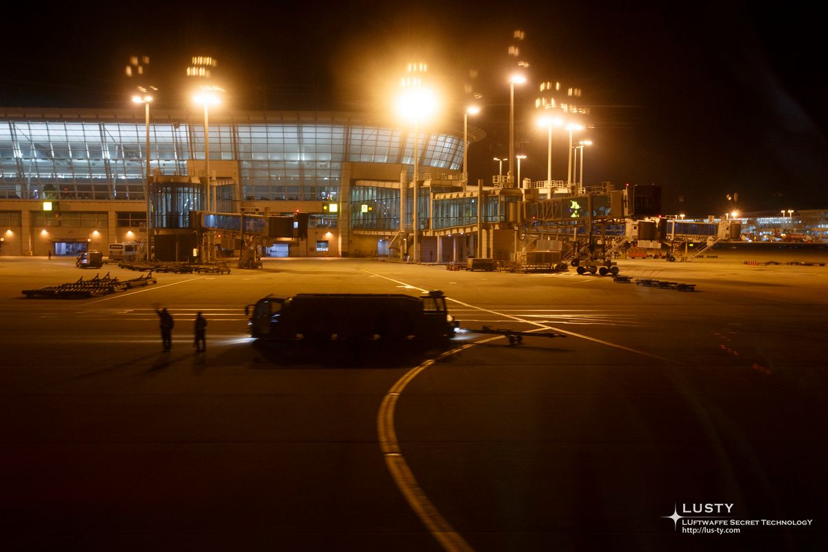 조명 밝힌 공항 터미널과 착륙장 차량