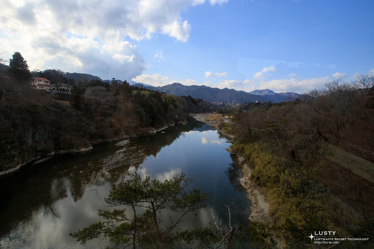 산과 나무가 비친 잔잔한 다리 아래 강