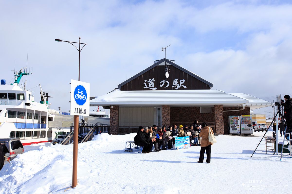 道の駅 간판 앞 눈밭과 대기 중 사람들