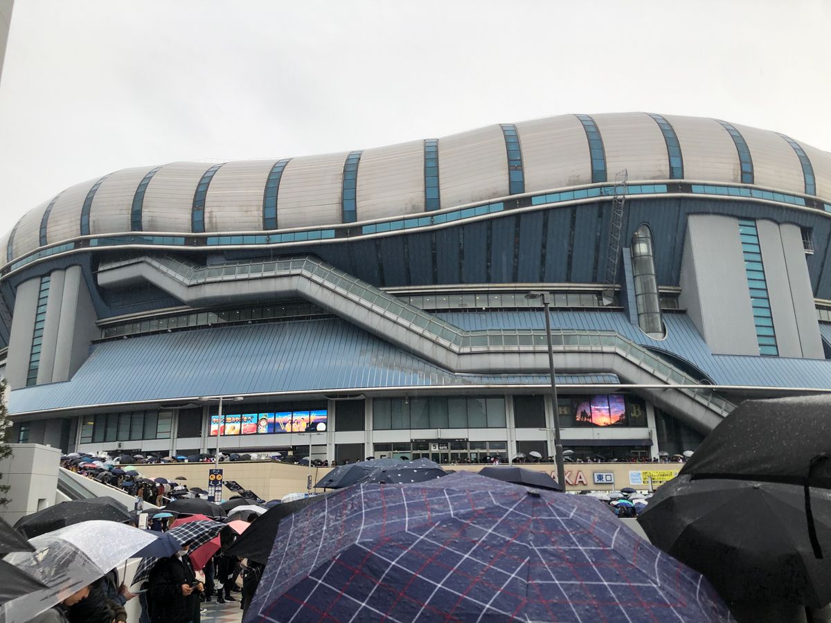 우산 든 사람 줄 선 거대한 돔 건물