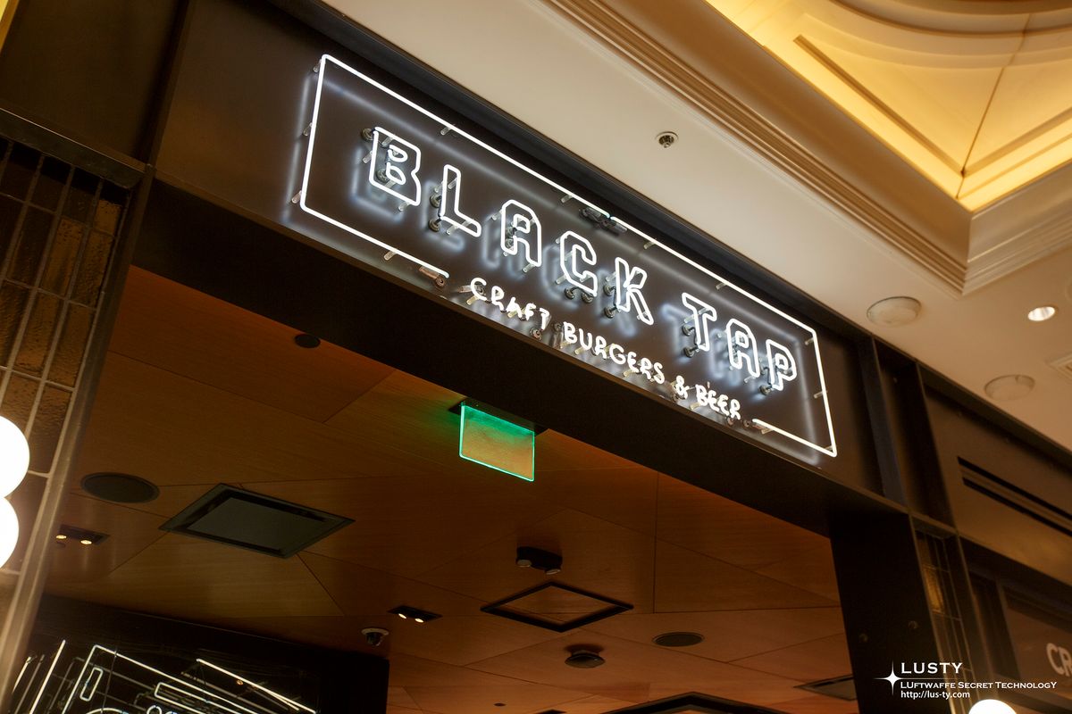 네온사인으로 “BLACK TAP” 문구가 빛나는 입구